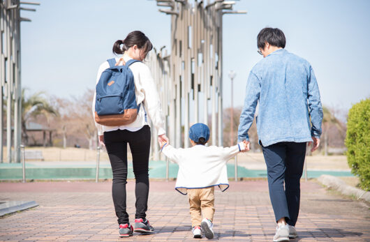 手を繋いで歩く家族